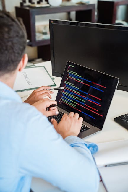 A close-up view of a computer screen displaying a code editor with HTML and CSS code, including tags such as <html>, <head>, <title>, <link>, and <meta>. The code is highlighted in various colors on a